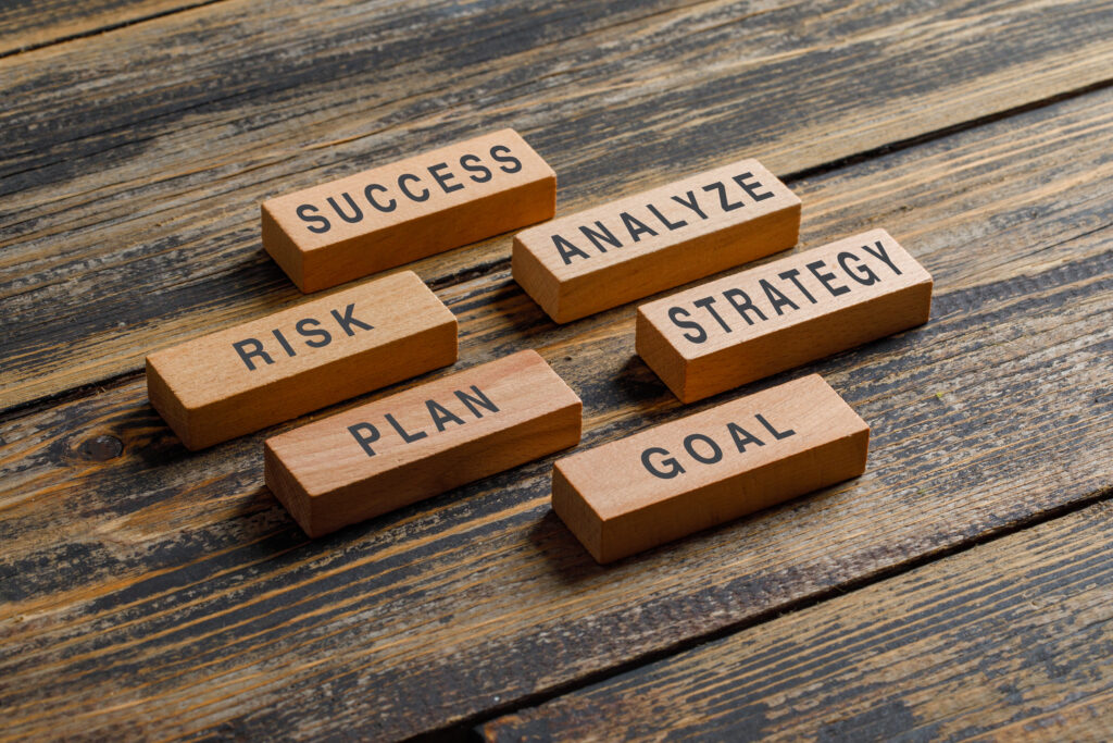 Business and marketing concept with wooden blocks on wooden background high angle view.